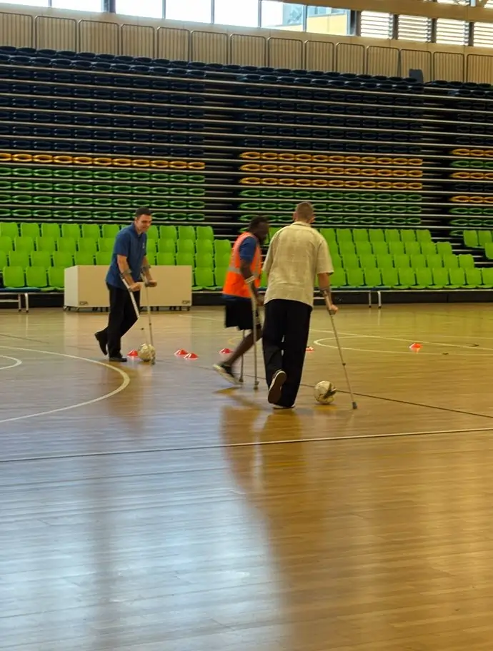 Participants using walking aids during an inclusive indoor soccer activity Participants using walking aids during an inclusive indoor soccer activity